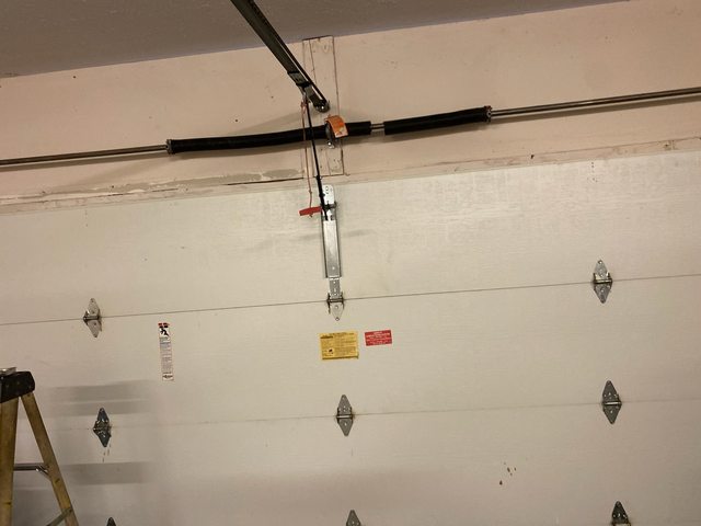 Old broken torsion spring — before replacement